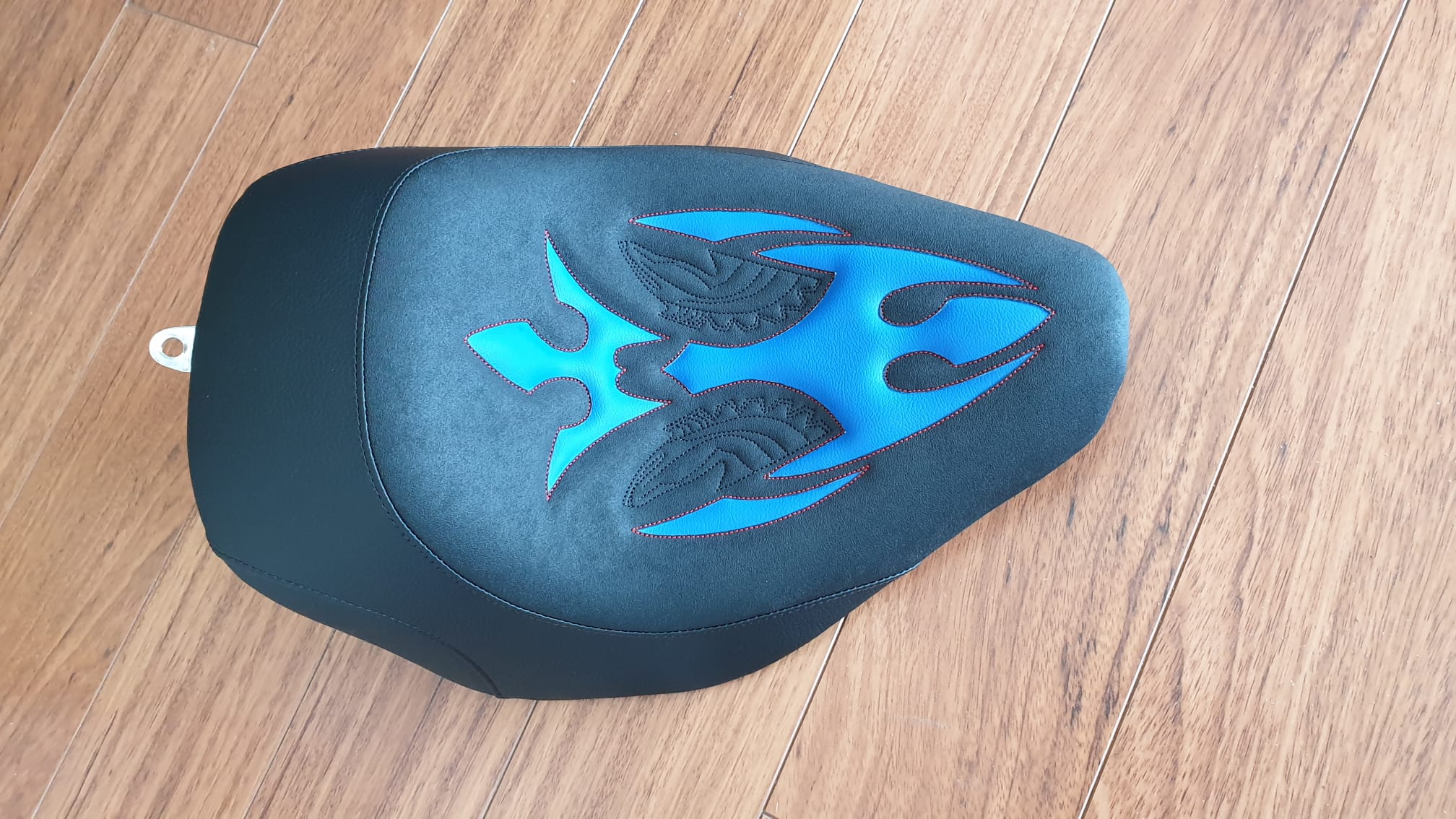 Bezug Alcantara Look schwarz, für Muster blaue Teile unterlegt, rot genäht, schwarzes Logo genäht.